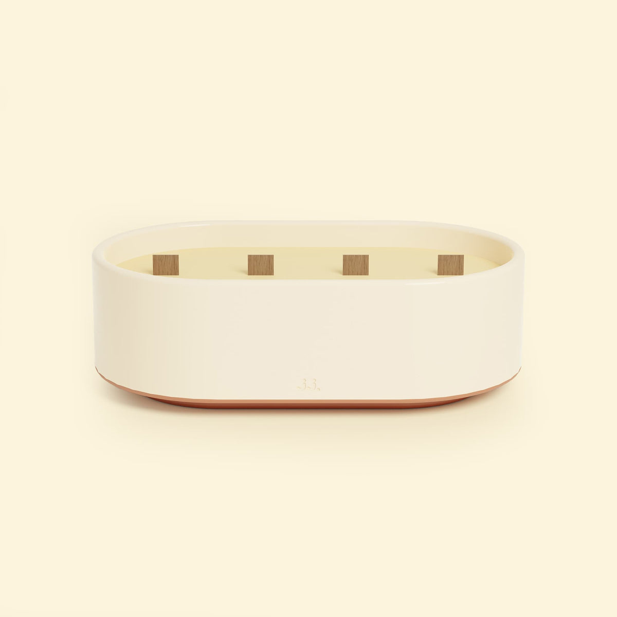 Bougie Totem L Beige ivoire – Citronnelle & Citron, grande bougie ovale à triple mèche en bois, posée sur un fond beige clair.
