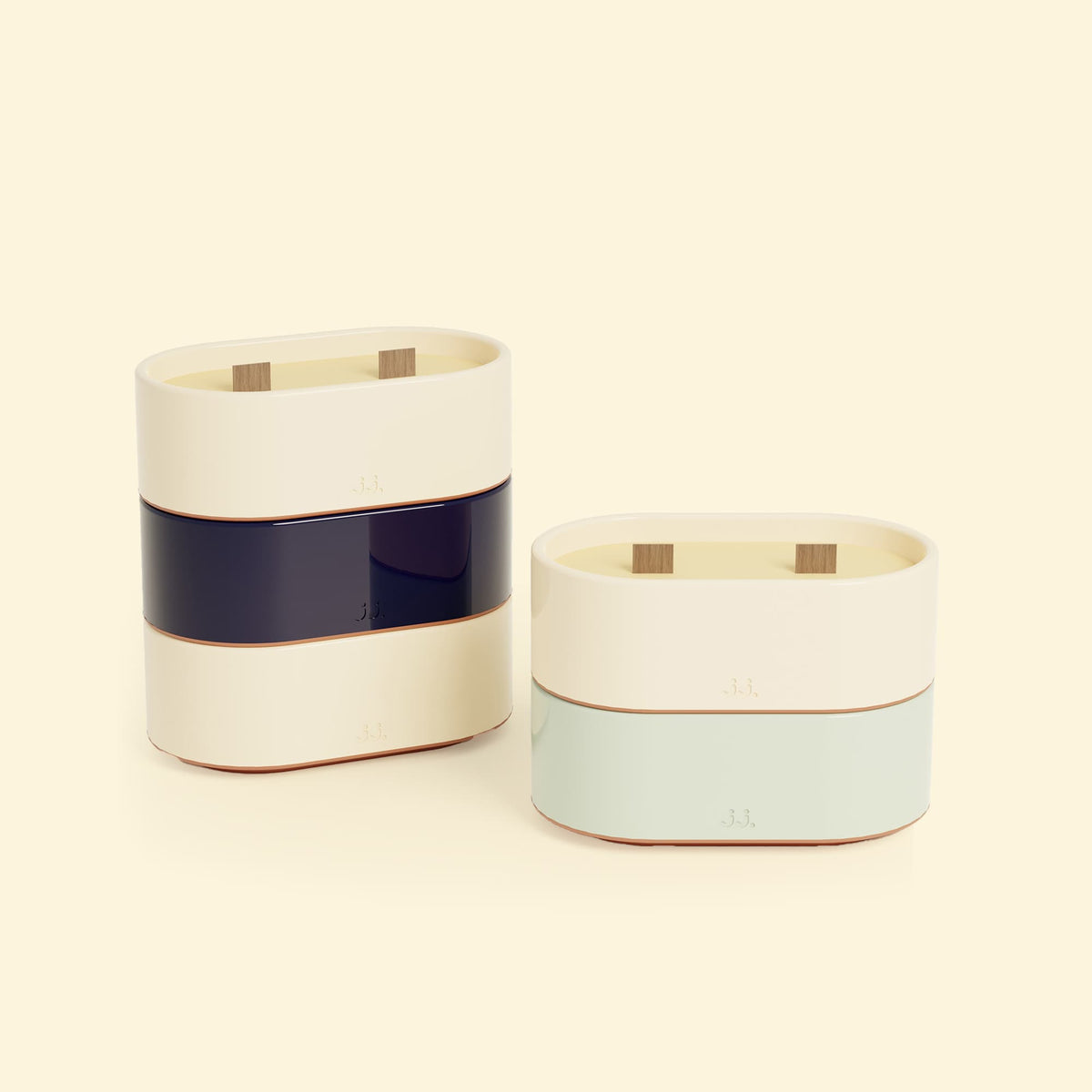 Bougies Totem S Beige ivoire – Citronnelle & Citron, Bleu marine – Citronnelle & Sel de mer et Vert d’eau – Citronnelle & Eucalyptus, deux bougies ovales à double mèche en bois, posées sur un fond beige clair. ::visuel:citron,sel,eucalyptus