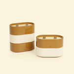 Bougies Totem S Brun terre de sienne – Citronnelle & Fleur d’oranger et Beige ivoire – Citronnelle & Citron, deux bougies ovales à double mèche en bois, posées sur un fond beige clair.::visuel:citron