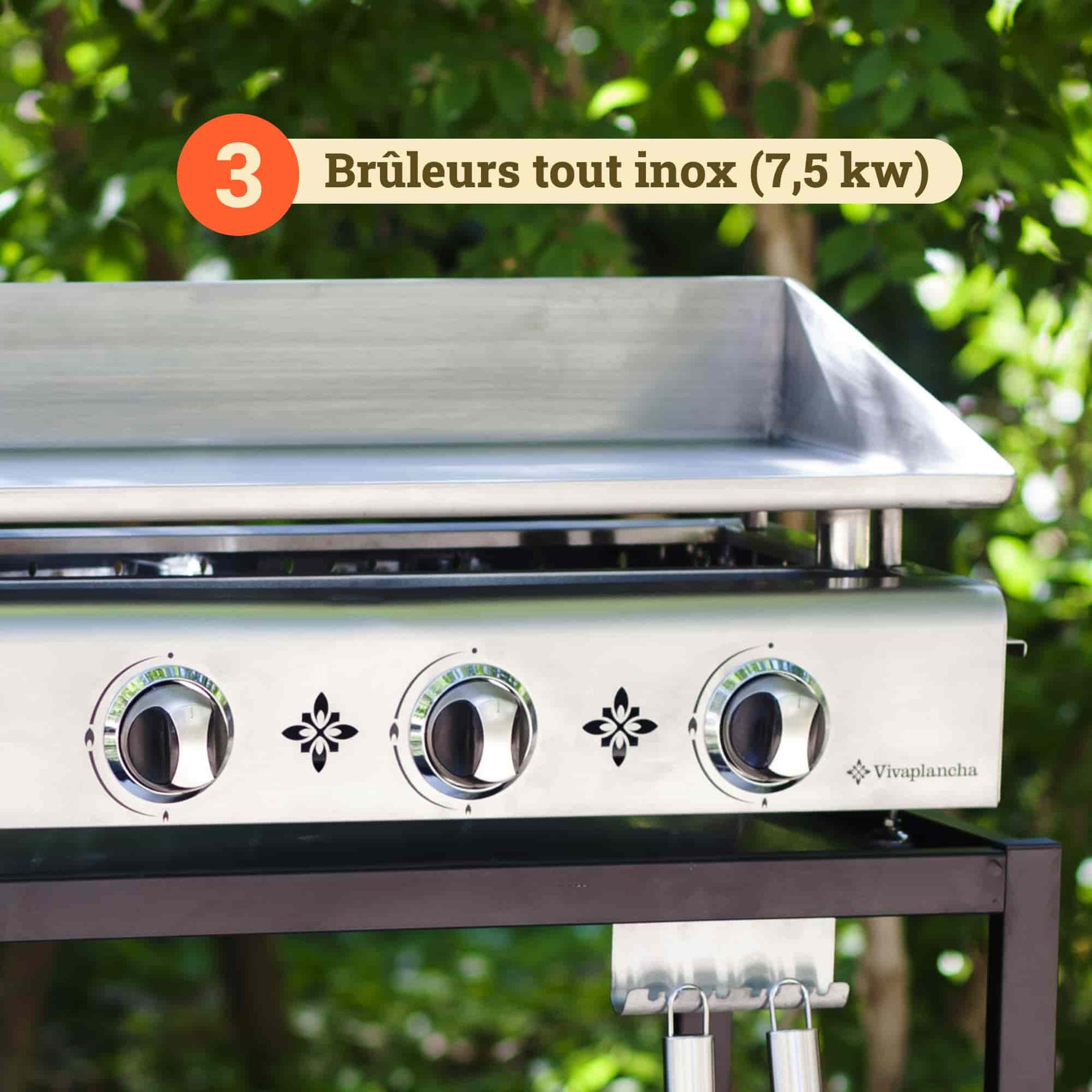 Plan rapproché de la plancha Vivaplancha montrant ses trois brûleurs tout inox (7,5 kW), avec les boutons de réglage en façade et un badge illustrant la puissance des brûleurs.
