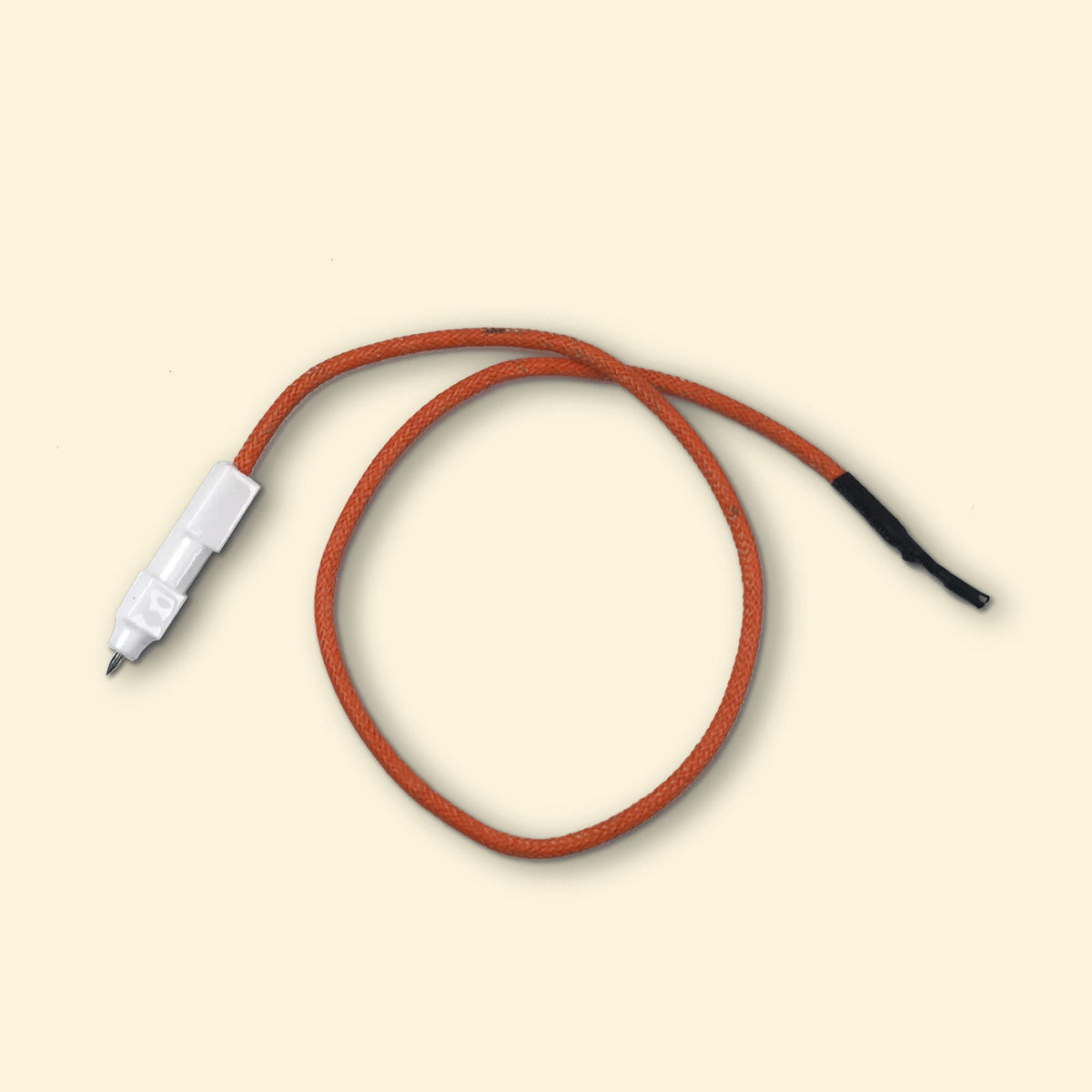 Câble piezo pour plancha gaz Vivaplancha, cordon orange avec allumeur céramique blanc, présenté sur fond beige.