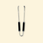 Grande pince en inox avec double manches noirs, vue de face sur fond uni, idéale pour saisir et retourner les aliments sur la plancha.