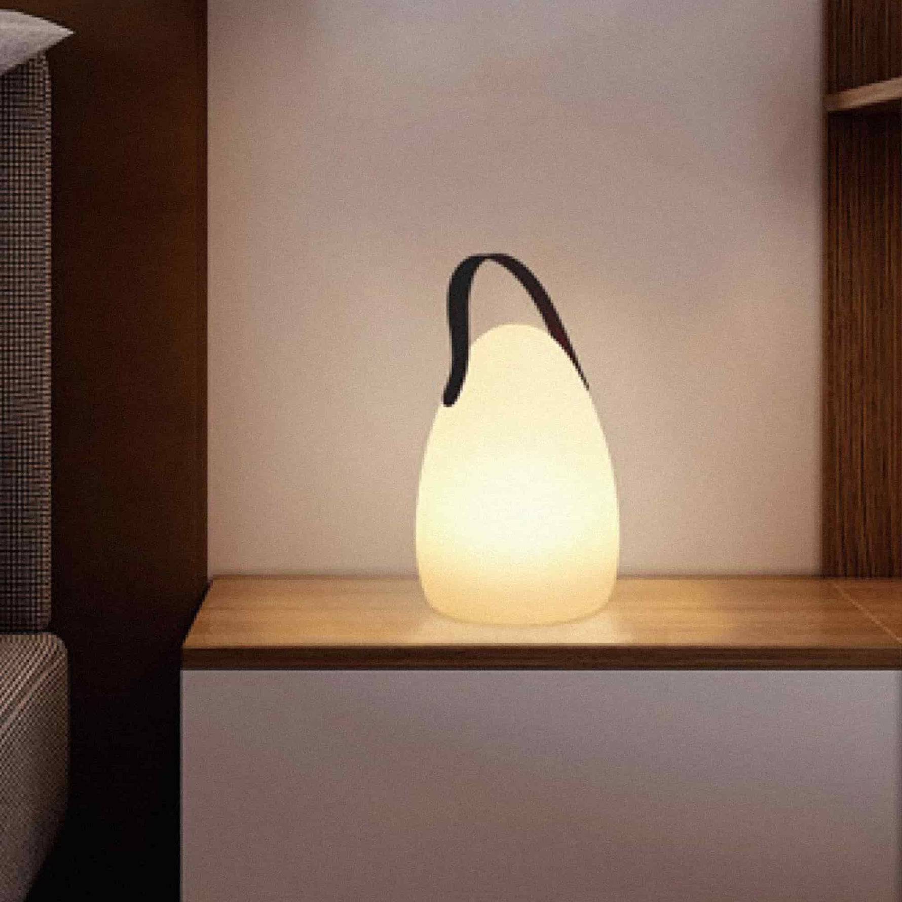 Lampe solaire d’extérieur en forme d’œuf, allumée et posée sur une étagère en bois, diffusant une lumière chaude dans une ambiance intérieure cosy.