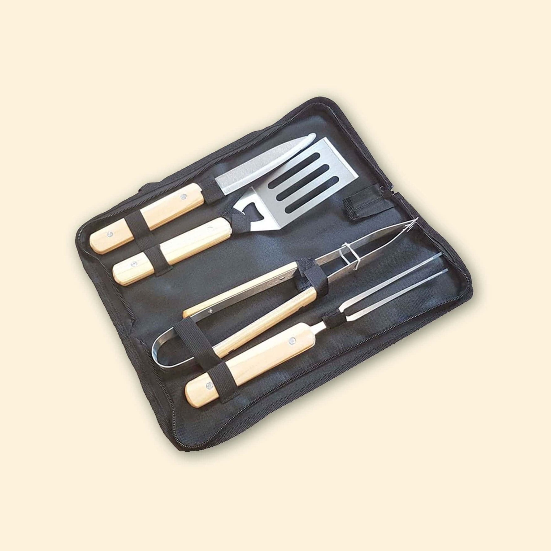 Ensemble de quatre ustensiles de cuisson avec manches en bois (couteau, spatule, pince et fourchette), rangés dans une housse noire ouverte.