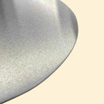 Gros plan sur la surface brossée en inox d’une grande pelle à pizza, montrant le bord arrondi et la finition métallique.